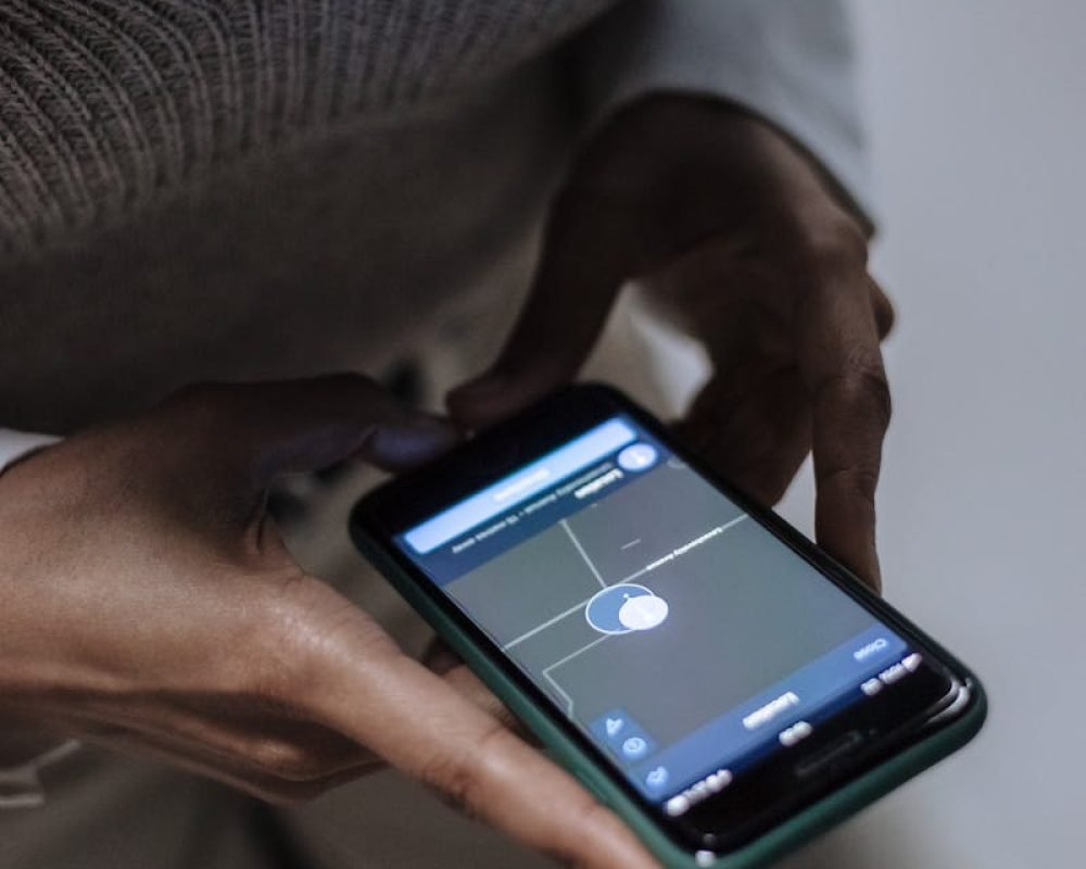 Transporte Santana Carrasco Valdeolmos - Close-up of a woman holding a smartphone with GPS navigation displayed, emphasizing technology and connectivity.